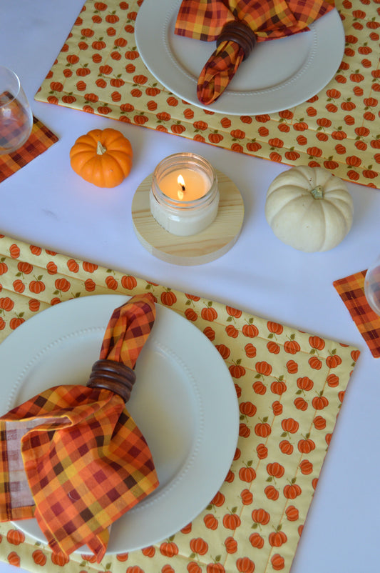 table setting with pumpkin placemat, white plate and orange plaid napkin in napkin ring