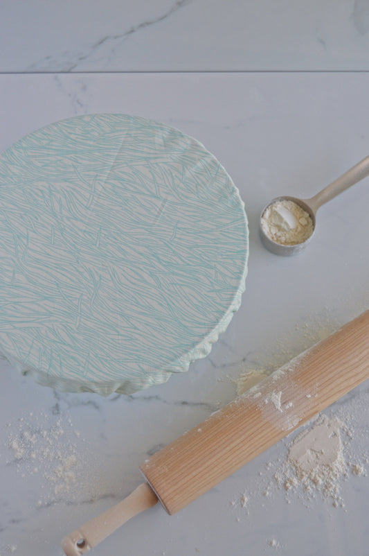 glass bowl covered and rolling pin with flour