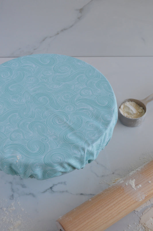 blue swirl wave design bowl cover next to rolling pin