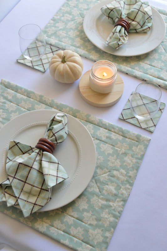 dining table setting with matching placemats and napkins in blue leaf and plaid design